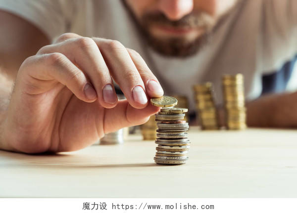 男人堆叠硬币在桌子收入提升